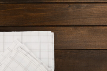 Kitchen towel on wooden table, top view. Space for text