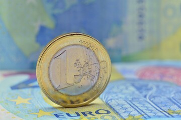 Moneda de un euro destacando sobre billetes de 20 euros