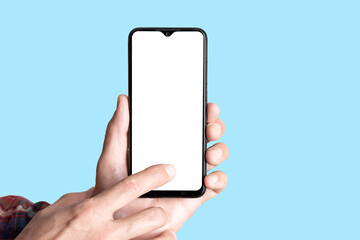 Empty smartphone in hand on colored blue banner background. Mockup phone with blank screen on minimal background