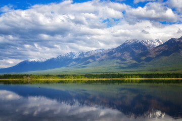 Landscape with mountains reflecting in the water on sunny day. Buryatia, Tunkinskaya valley