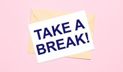 On a light pink background - a craft envelope. It has a white sheet of paper that says TAKE A BREAK