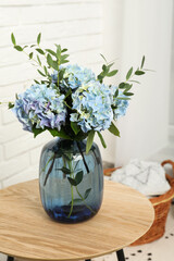 Beautiful blue hortensia flowers in vase on table indoors