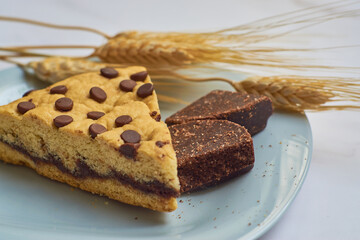 Slice of homemade chocolate cake with chocolate chips on a marble table.