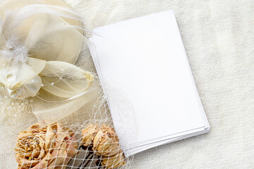 empty letterhead for the inscription, dry roses and a white hat with a veil. Female wedding background.