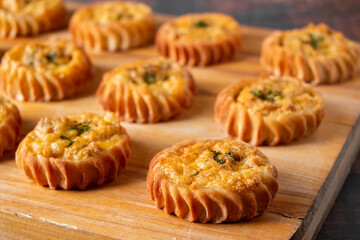 Muffins with vegetables and cheese on wooden board. Fresh homemade cakes for a healthy diet. Preparation of seasonal fall food.