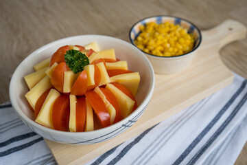 dish decoration with tomato, cheese and corn on a cutting board