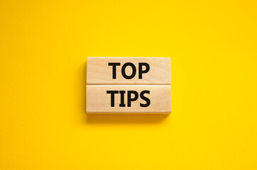 Top tips symbol. Concept words Top tips on wooden blocks on a beautiful yellow background. Business and Top tips concept, copy space.