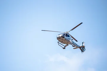 Fototapeten Flying helicopter in blue sunny sky © alpegor