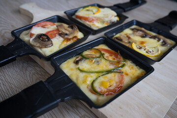 raclette preparation with gratin cheese and vegetables