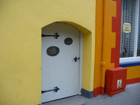 Petit porte de maison de nain coloré en jaune, accès à une cave pour ranger du vin, ancien et tout en bois, accès limité, style irlandais et historique 