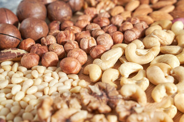 Many different nuts. Assortment healthy snacks. Mediterranean diet. Dry vegan charcuterie. Variety party pile. Kitchen table. Fat nutrients