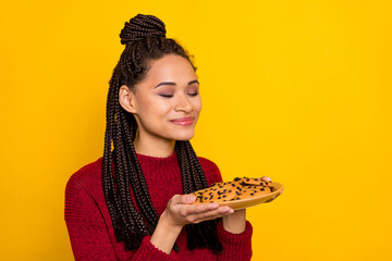 Photo of sweet cute dark skin woman dressed red sweater enjoying cookies aroma empty space smiling...