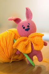 Pink hare with an orange scarf and a ball of thread, handmade and hobby