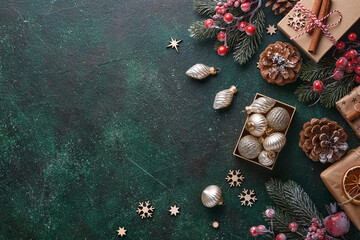 Christmas fir tree branches, Christmas balls, gift box, wooden snowflakes and stars on green...