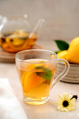 Tea in glass cup with lemon, mint and honey. Delicious fruit, herbal teapot and cup.