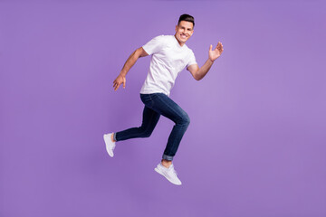 Fototapeta na wymiar Full body profile side photo of young man happy positive smile go walk run jump hurry isolated over violet color background