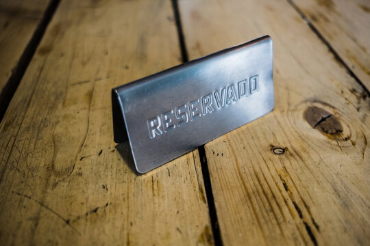 a metal reservation sign on a wooden table in a restaurant