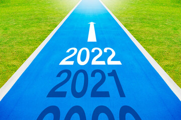 The number 2021-2022 is written on a bicycle track in the empty blue asphalt road. health and...