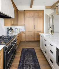 Kitchen detail in new luxury home. Features large island with faucet, large gas range and oven,...