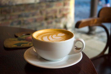 Cup of cappuccino on a vintage table on the background of the enraged city.