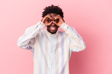 Young african american man isolated on pink background showing okay sign over eyes