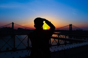 silhouette of a person taking a shot on a bridge in New York - 456771330