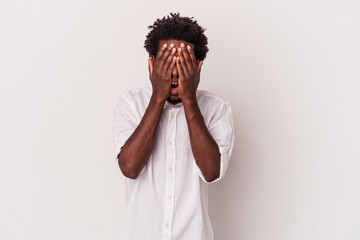 Young african american man isolated on white background  having fun covering half of face with palm.