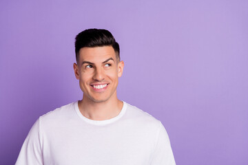 Photo of attractive young dreamy man look empty space imagine idea isolated on purple color background