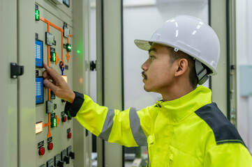Electrical engineer man checking voltage at the Power Distribution Cabinet in the control...
