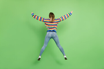 Fototapeta na wymiar Full length body size rare view photo girl jumping wearing casual clothes isolated pastel green color background