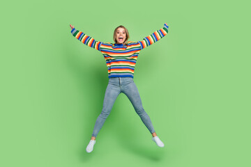 Fototapeta na wymiar Full length body size photo girl in striped sweater jumping up overjoyed laughing isolated pastel green color background
