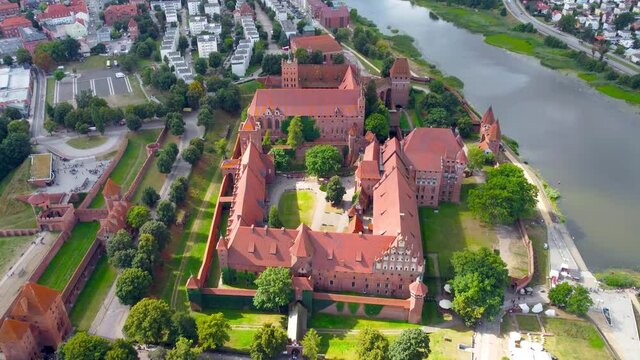 Fly over Malbork Castle along river Nogat in Poland. Malbork Castle is the largest castle in the world measured by land area.