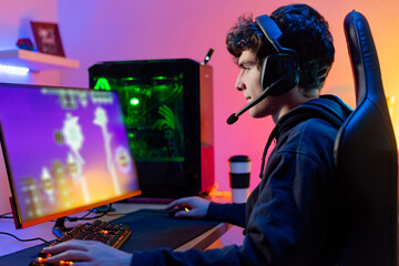 Male player in headset enjoying computer game