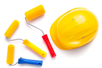 Paint roller and hard hat isolated at white background. Construction helmet with tool