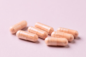 Goji Berry (Wolfberry) capsules. Immune system support. Dietary supplement on pink paper background. Close up. 