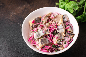 herring slice onion pieces pickled salted fish seafood fresh ready to eat meal snack on the table copy space food background rustic. top view keto or paleo diet food