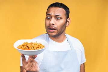 Portrait of of happy african american indian black man chef cooking pasta. Cooking, profession, haute cuisine, food and people concept isolated over yellow background.