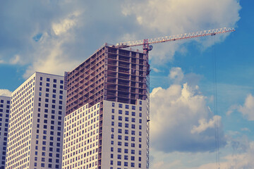 Fototapeta na wymiar Unfinished modern high-rise houses against the blue sky