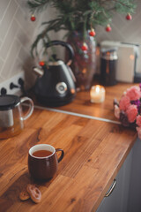 Fototapeta na wymiar Cozy home lifestyle: a cup of tea with cookies on a wooden table top with beautiful carnation flowers
