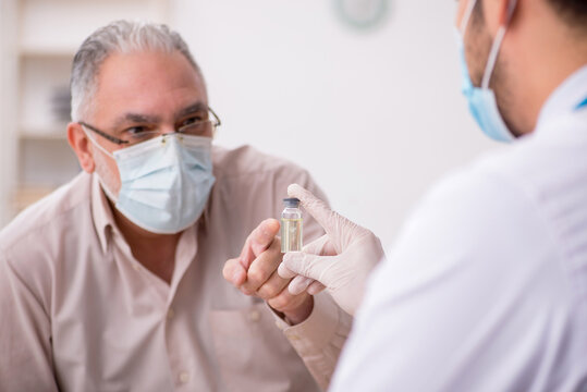 Old male patient visiting young male doctor in vaccination conce