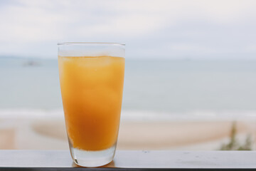 Fresh juice in a glass with sea view background in concept of summer.