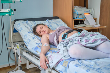 Woman on clinic bed with anesthesia at the time of labor pains. A pregnant woman gives birth in a...