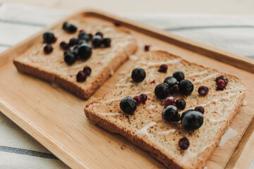 Homemade mixed berries toast breads served on wooden plate.