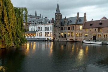 Fototapeta na wymiar Bruges, Belgium. September 30, 2019: Dock of the rosary and reflections in the water of the lights.