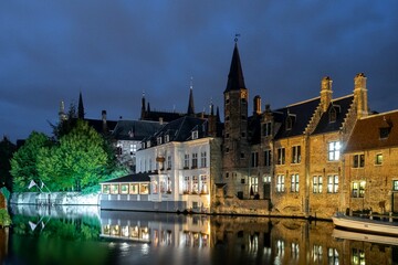 Bruges, Belgium. September 30, 2019: Muelle del Rosario at night and reflection in the water of the canal.