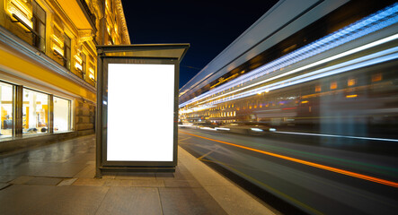 Vertical billboard screen light box. In night at the bus stop.
