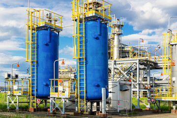 Two metal blue horizontal containers stand against the background of the blue sky. Gas processing. Chemical industry.