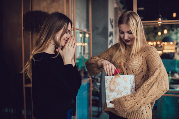 Fototapeta premium Young happy women opening presents at home