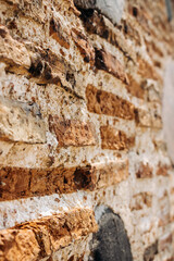 The wall of an old building made of red brick and stone. Brick wall close-up