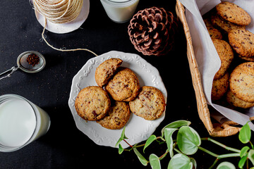 Cookies, boa plant leaves on black background. Close up. 